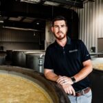 Nick Smith standing between fermenters in the rick house