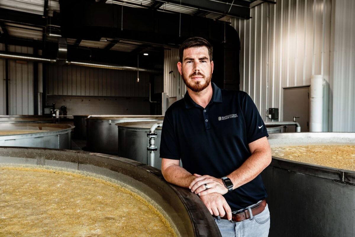 Nick Smith standing between fermenters in the rick house