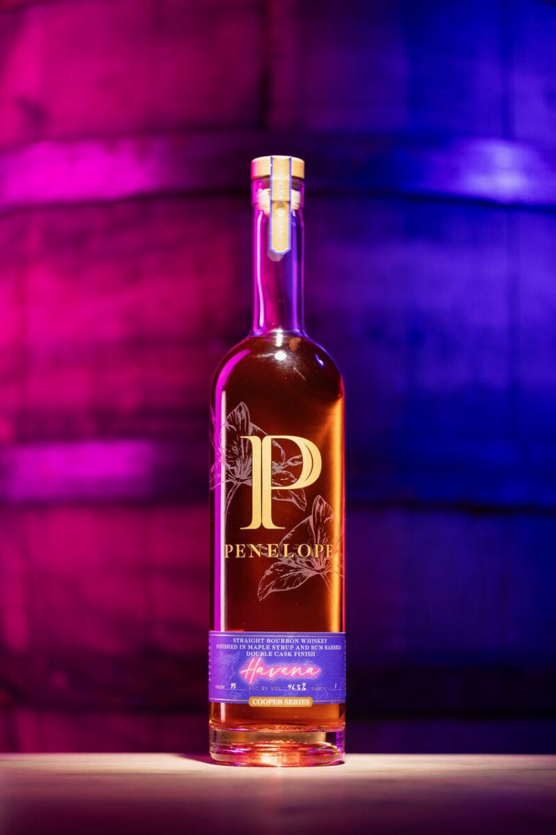 Bottle of Penelope Havana back lit with purple and blue