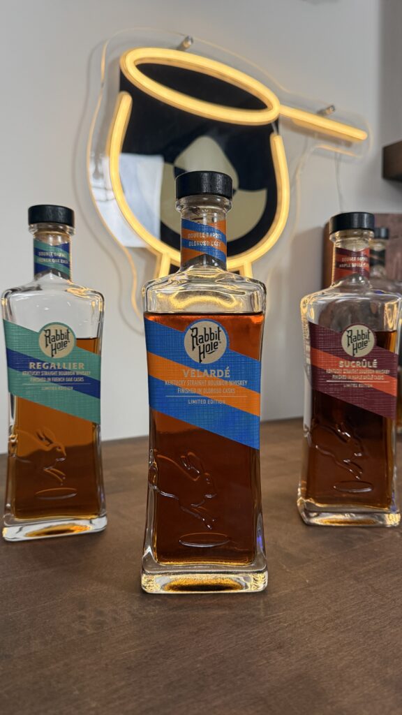 Rabbit Hole Distillery Exclusives Bottles With Bourbon Lens Logo in the background